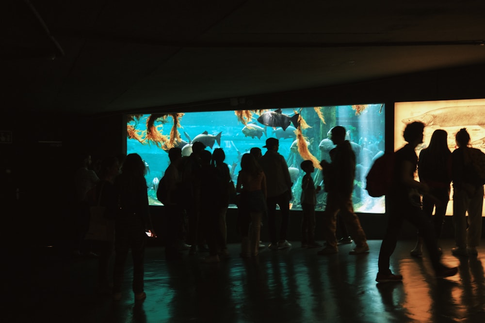 a group of people standing in front of a large screen