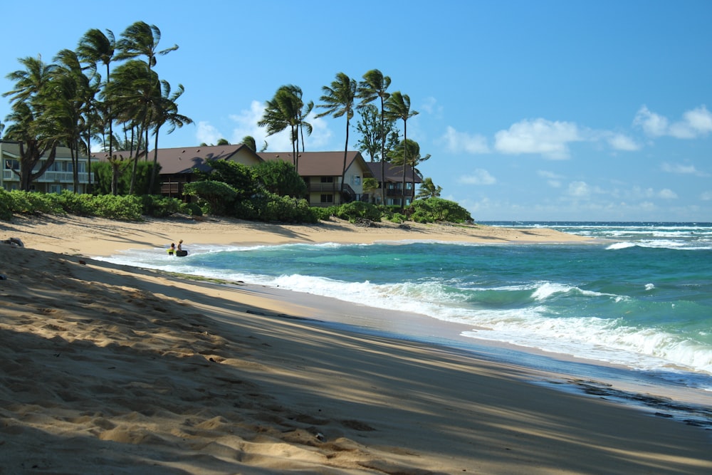 a sandy beach with a house in the background