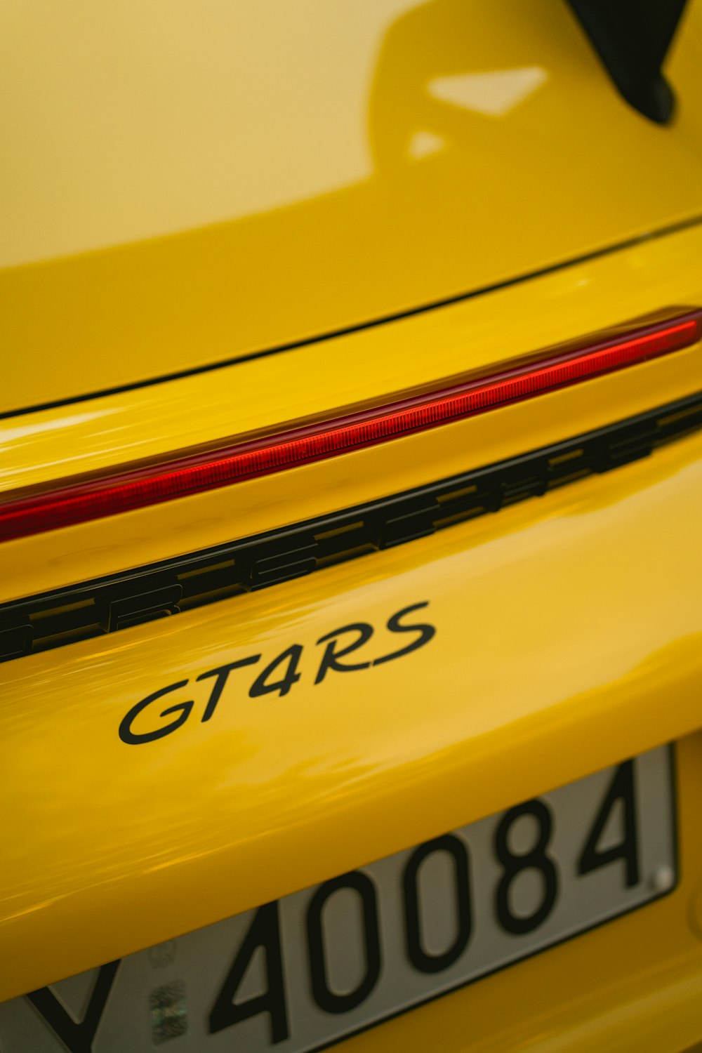 a close up of the rear end of a yellow sports car