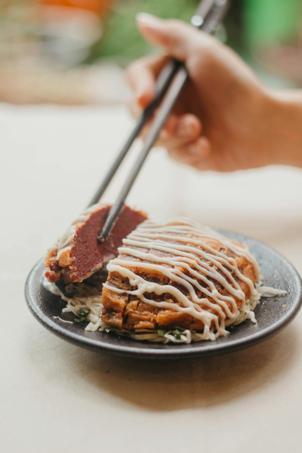 a person holding chopsticks over a plate of food