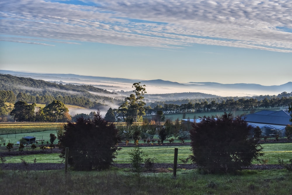 a scenic view of a farm in the mountains