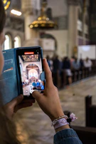 A person taking notes while watching a video course on evangelism on their smartphone.