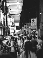 A dynamic black and white photo of a bustling city street at night.