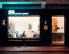 Modern barbershop interior with dark tones and golden highlights, showcasing a premium atmosphere