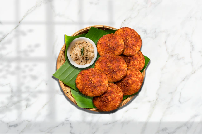 Close-up of golden crispy medu vada stacked on a banana leaf.