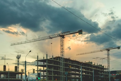 An aerial shot of multiple cranes working on a large building project.