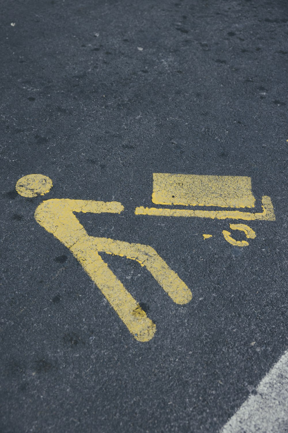 a yellow sign on the ground indicating a bench