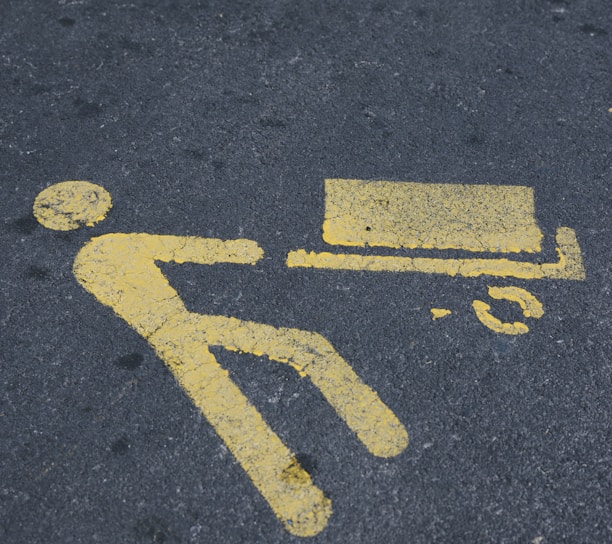 a yellow sign on the ground indicating a bench