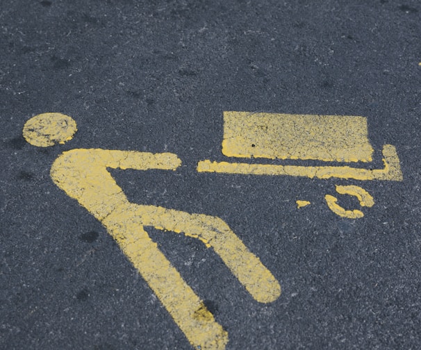 a yellow sign on the ground indicating a bench