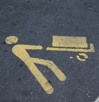 a yellow sign on the ground indicating a bench