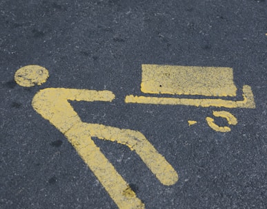 a yellow sign on the ground indicating a bench