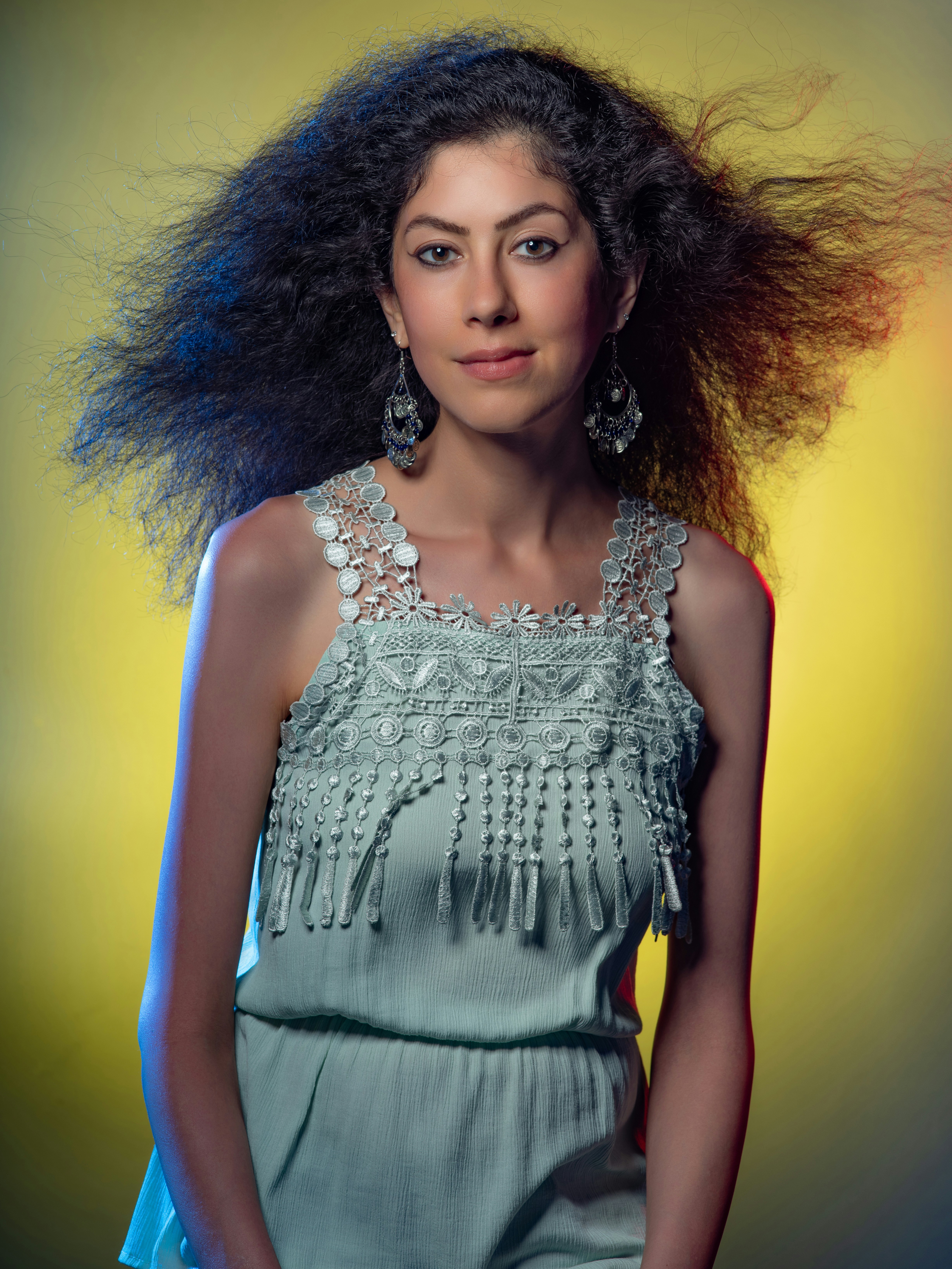 A woman with long hair standing in front of a yellow background photo ...