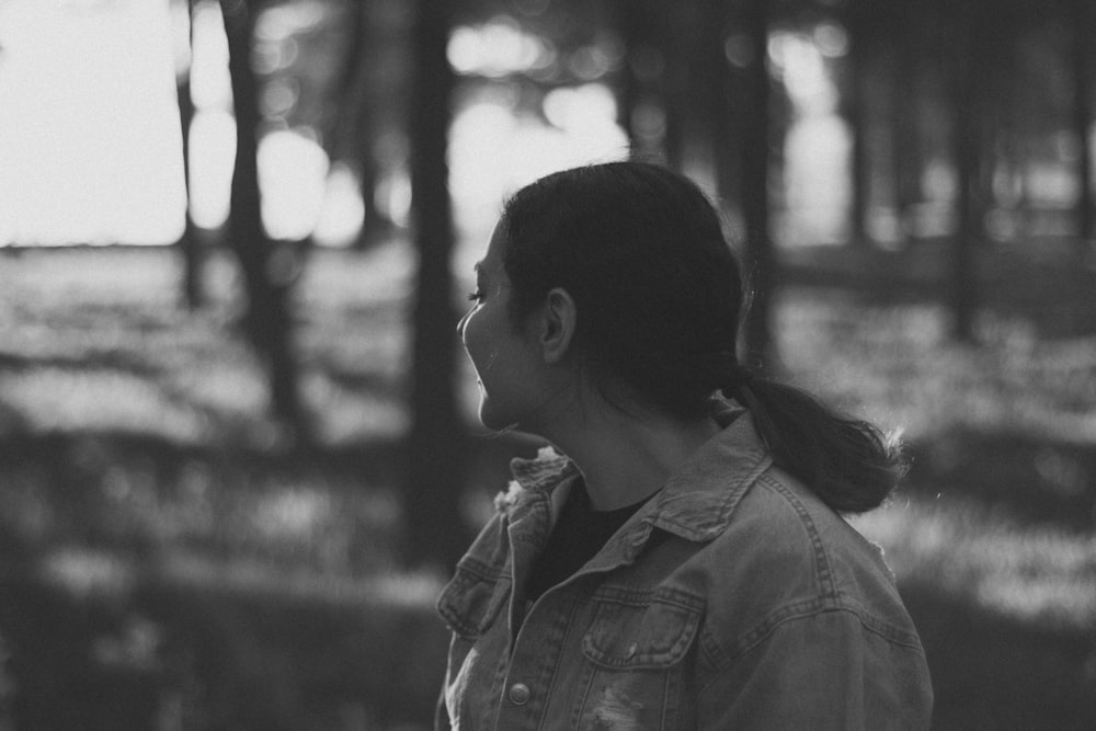 a woman standing in front of a forest