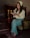 A woman smiling while reading a book in a cozy setting.