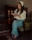 A woman smiling while reading a book in a cozy setting.