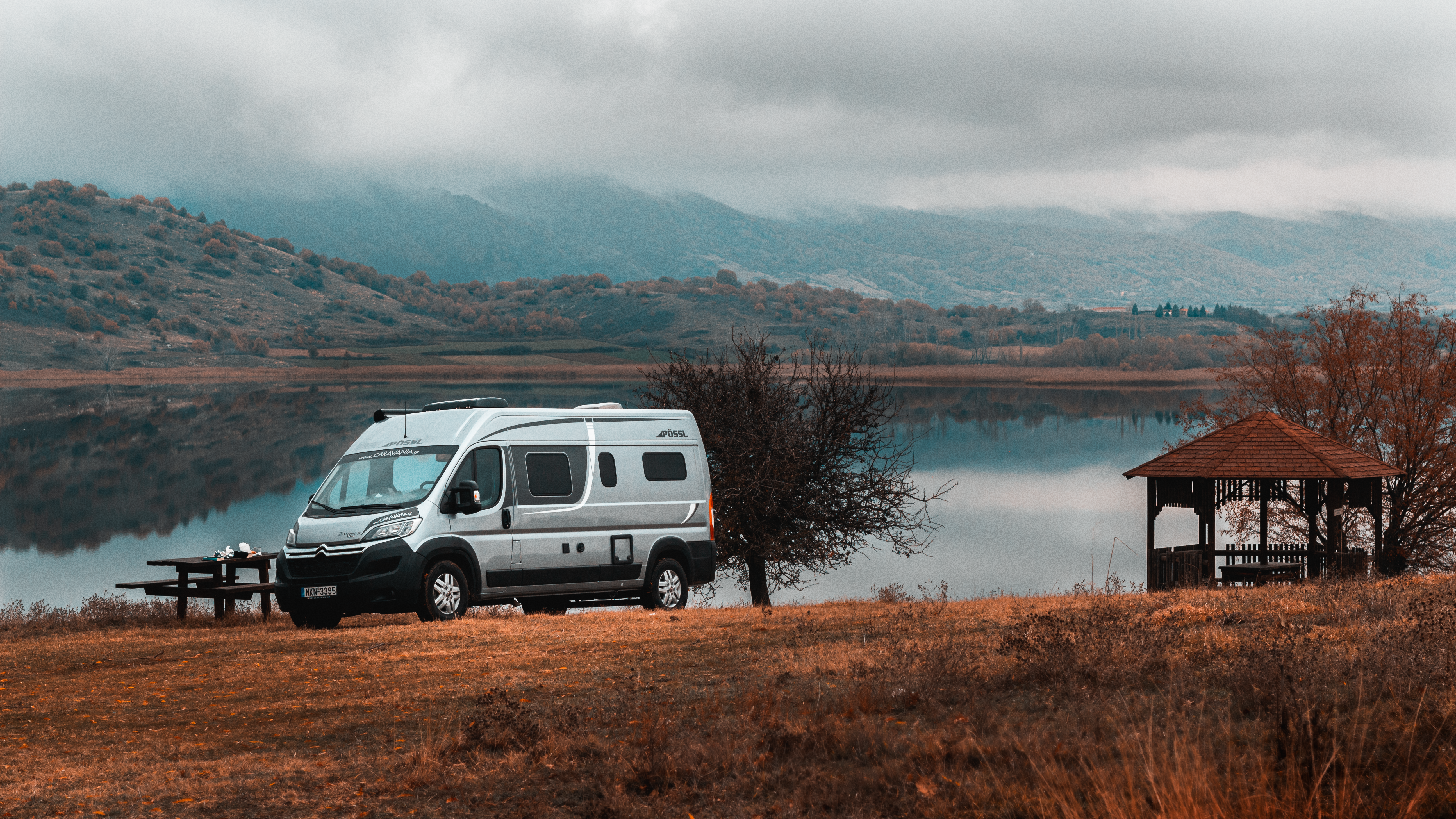 a white van parked next to a lake