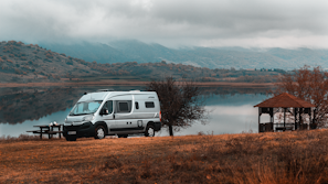 Our camper van parked by a serene lake.