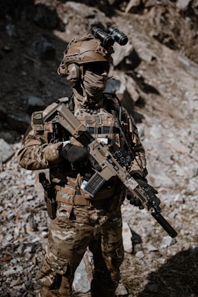 a man in camouflage holding a rifle in his hand