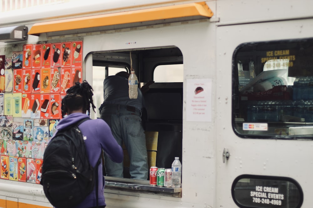 a man standing in the open door of a food truck