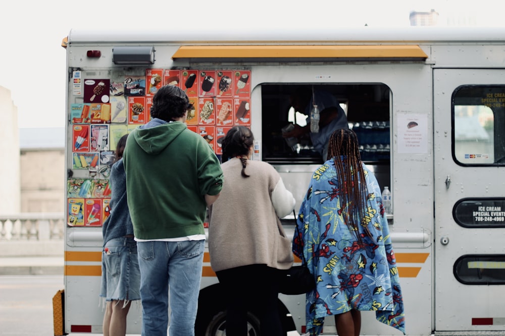 a group of people standing in front of a food truck