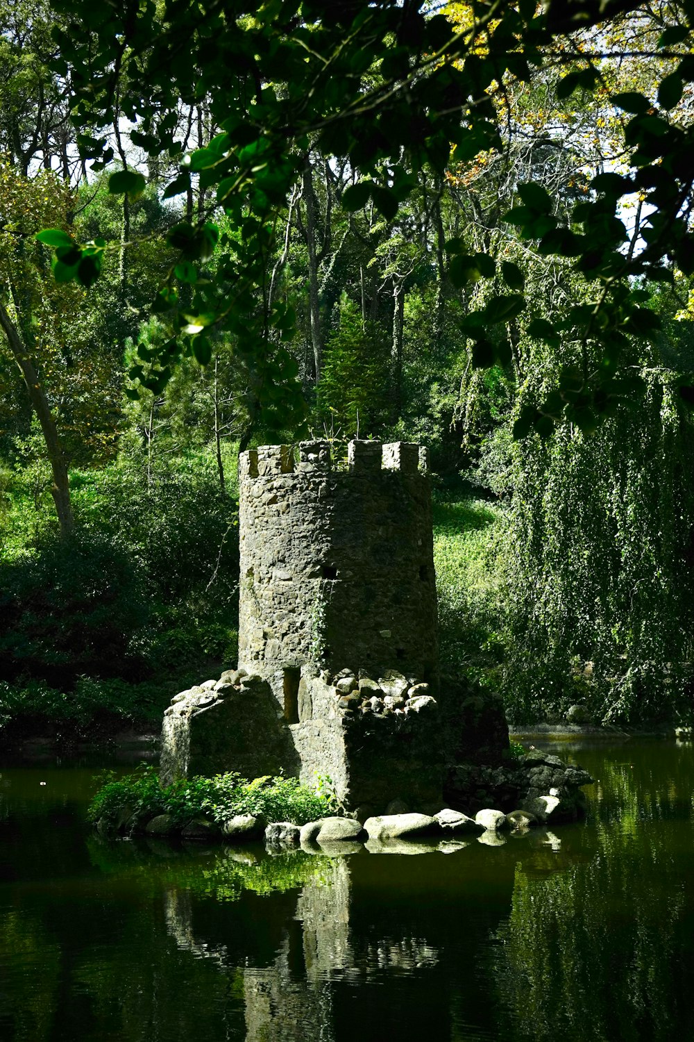 a stone tower sitting in the middle of a lake