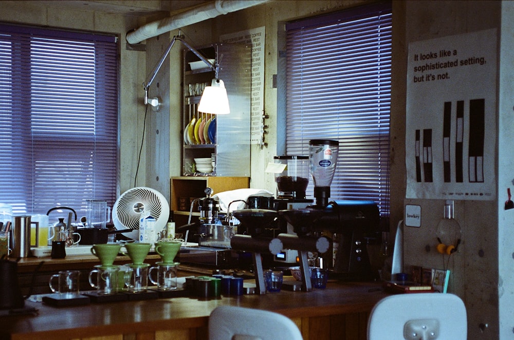 a room with a fan, a table, and several windows