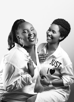 Two friends laughing together at a music concert, enjoying the vibrant atmosphere.