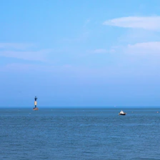 Minimalist ocean harbor scene with a glowing blue lighthouse symbolizing guidance and security in a digital world.