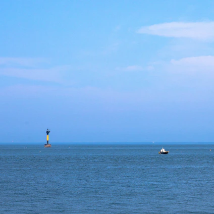 Minimalist ocean harbor scene with a glowing blue lighthouse symbolizing guidance and security in a digital world.