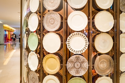 A close-up of a vintage triangular plate and a round plate displayed on a wooden table.