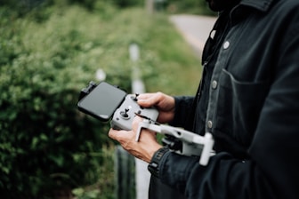 Operator controlling a drone with a tablet in an outdoor setting