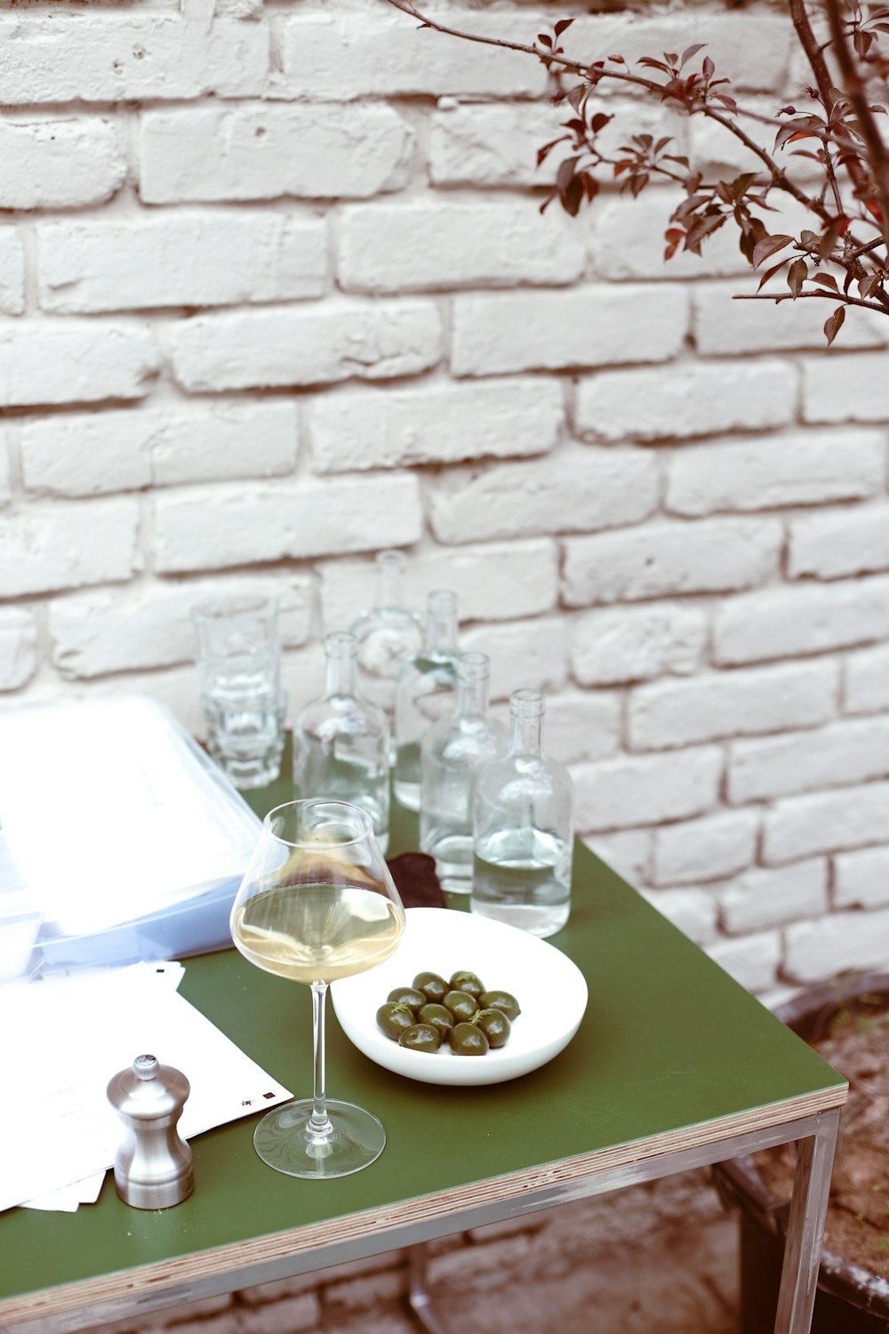 a table topped with glasses of wine and a plate of olives