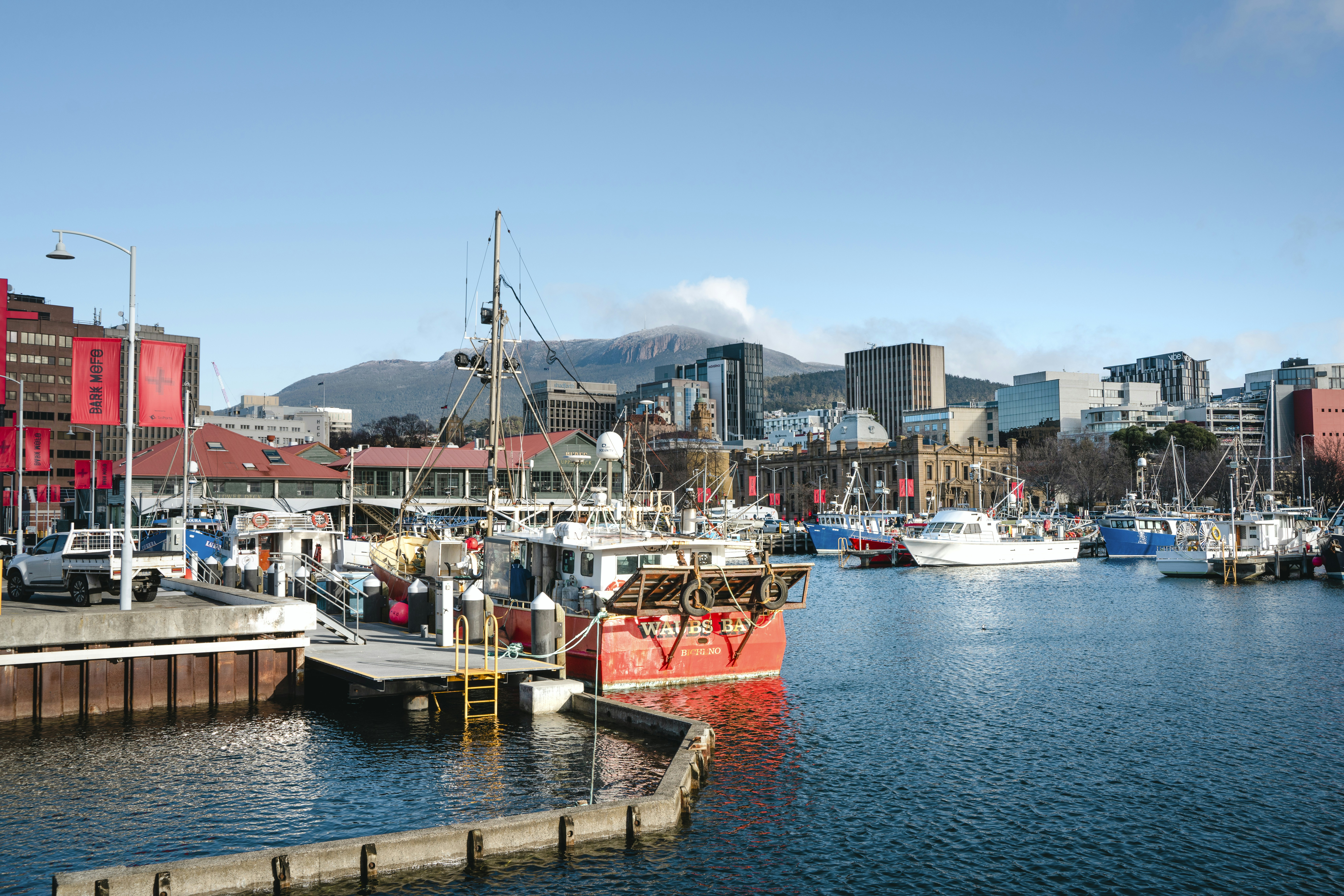 a harbor filled with lots of boats next to tall buildings, 