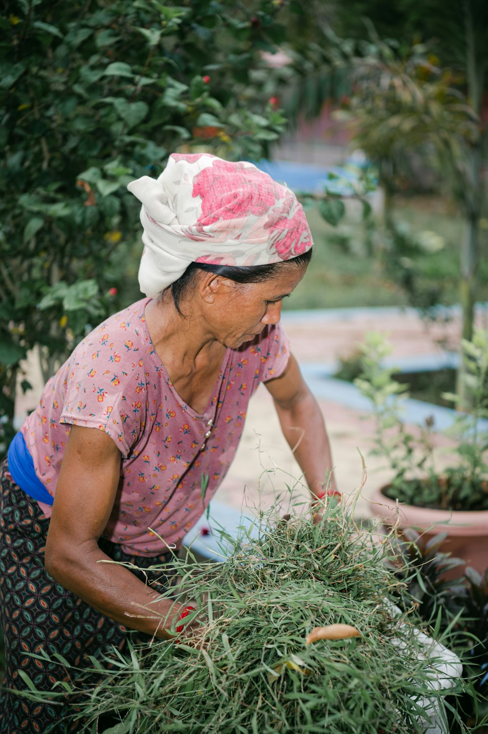 an older woman is working in a garden
