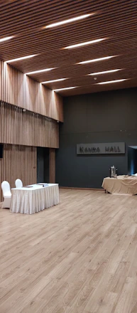 A bright, welcoming village hall interior set up for a community event with tables, chairs, and soft natural light.