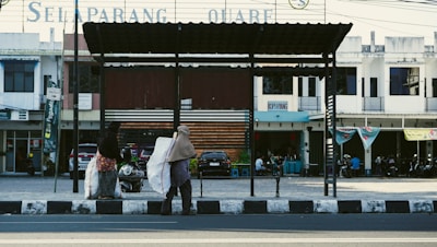Women carrying large capacity foldable shopping bags at a local market.