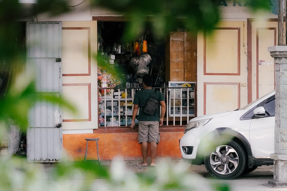 a man standing in front of a small store