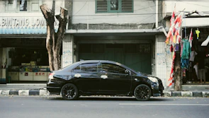 A comfortable rental car parked near a famous Jogja landmark