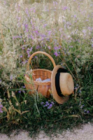 A stylish sun hat resting on a picnic blanket in a blooming meadow