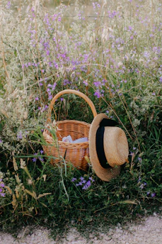 A stylish sun hat resting on a picnic blanket in a blooming meadow
