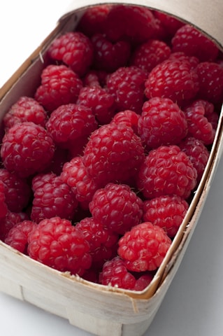 Close-up of ripe strawberries and raspberries freshly picked in a basket.