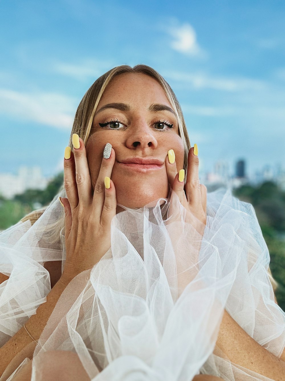 a woman with yellow nails and a white dress