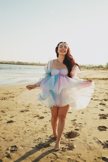 A sunlit beach scene with a model wearing a flowing linen shirt and relaxed shorts, barefoot on warm sand.