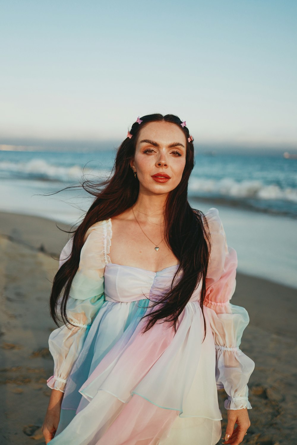 a woman in a dress standing on a beach