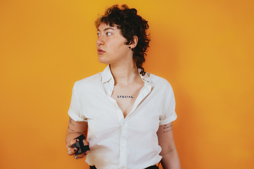Portrait of a nonbinary autistic person in a studio setting with a stim toy in their hand,