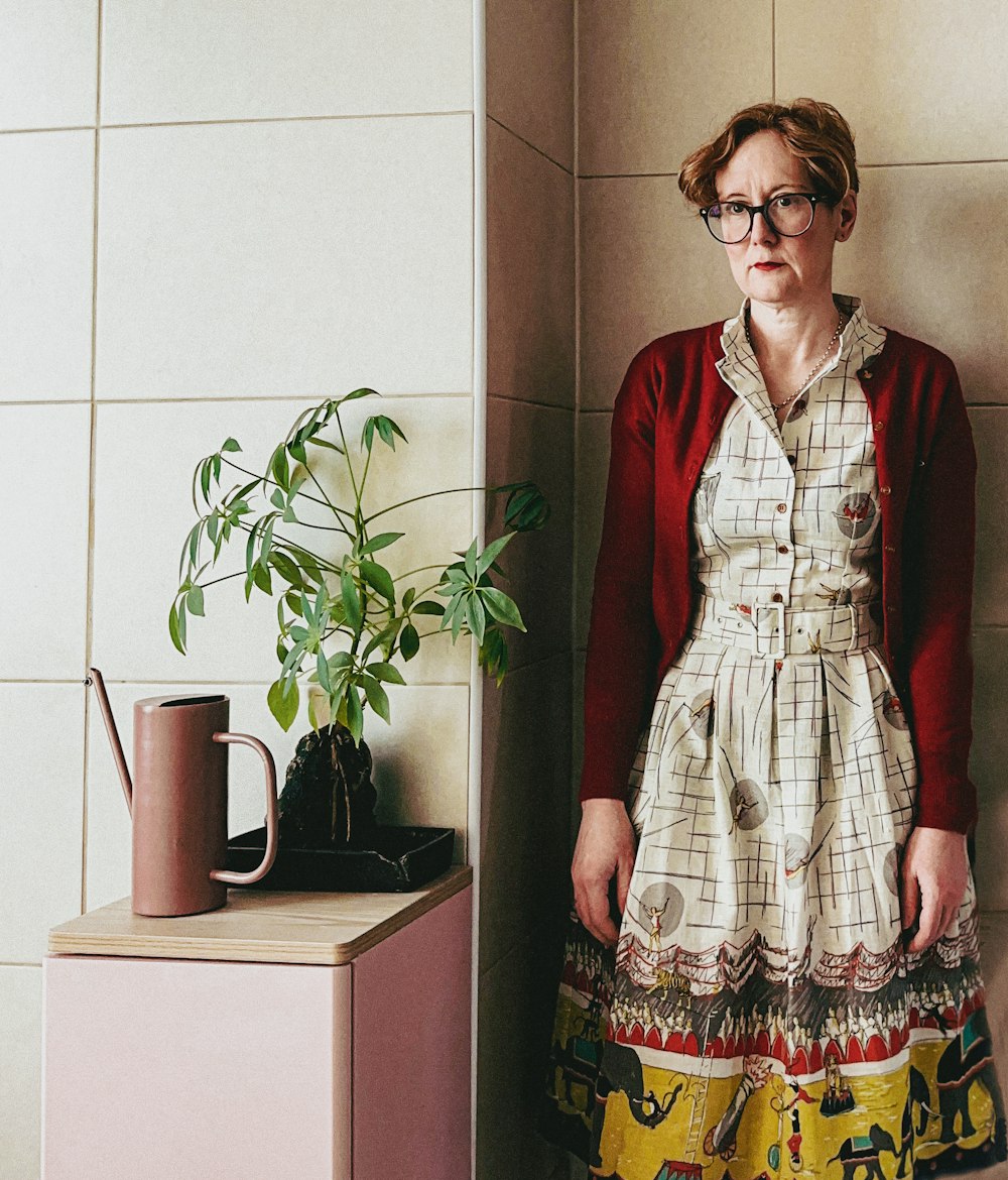 a woman standing next to a potted plant