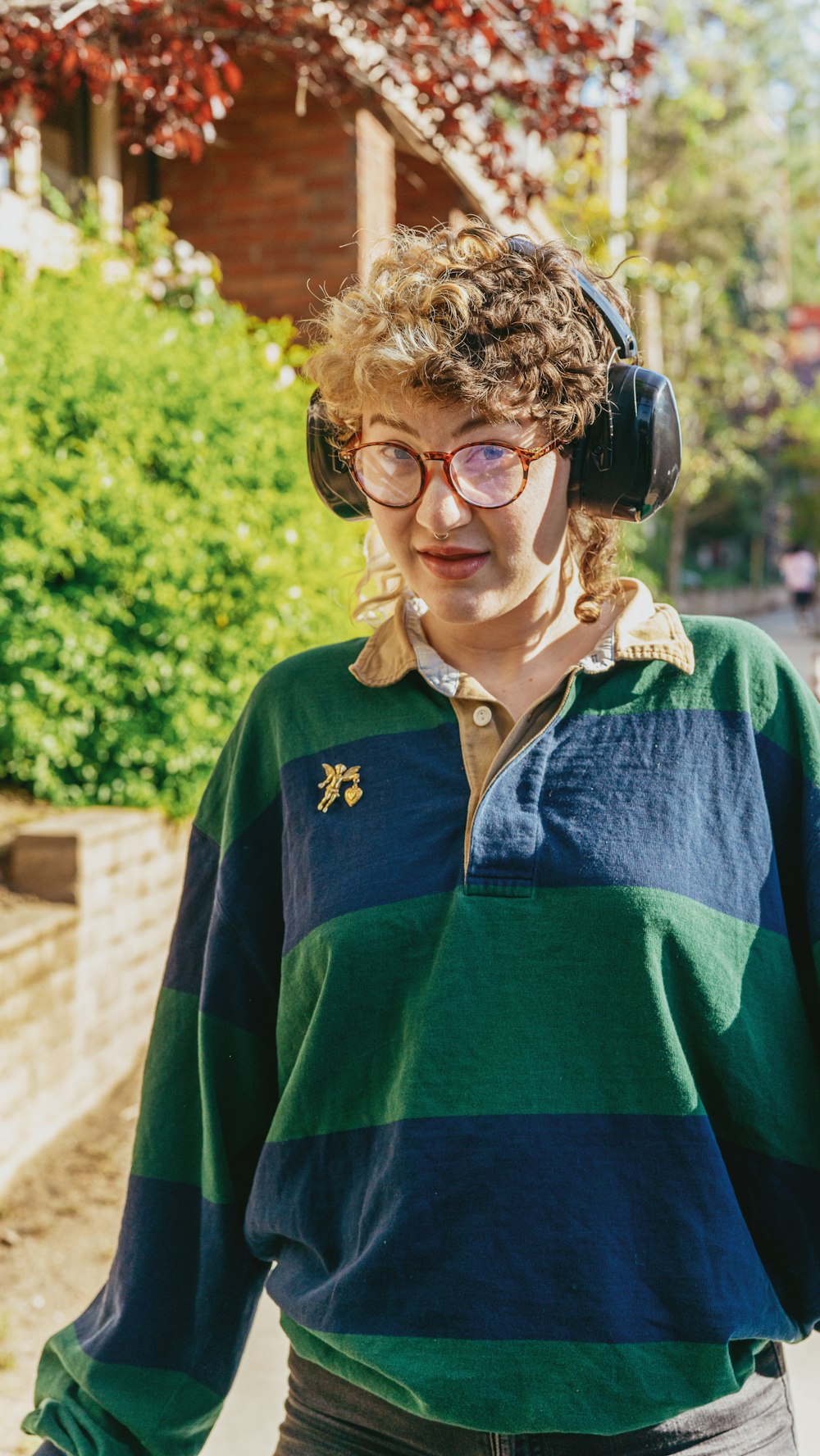 Porträt einer nichtbinären autistischen Person im Freien mit Kopfhörern