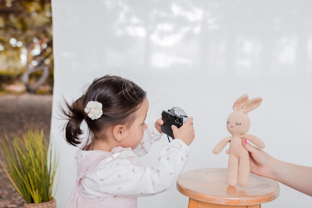 a little girl playing with a stuffed animal