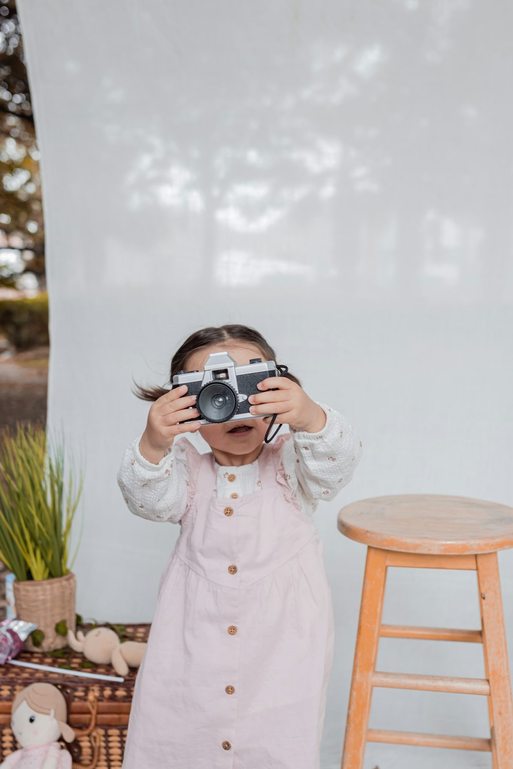 Une petite fille tenant un appareil photo contre son visage