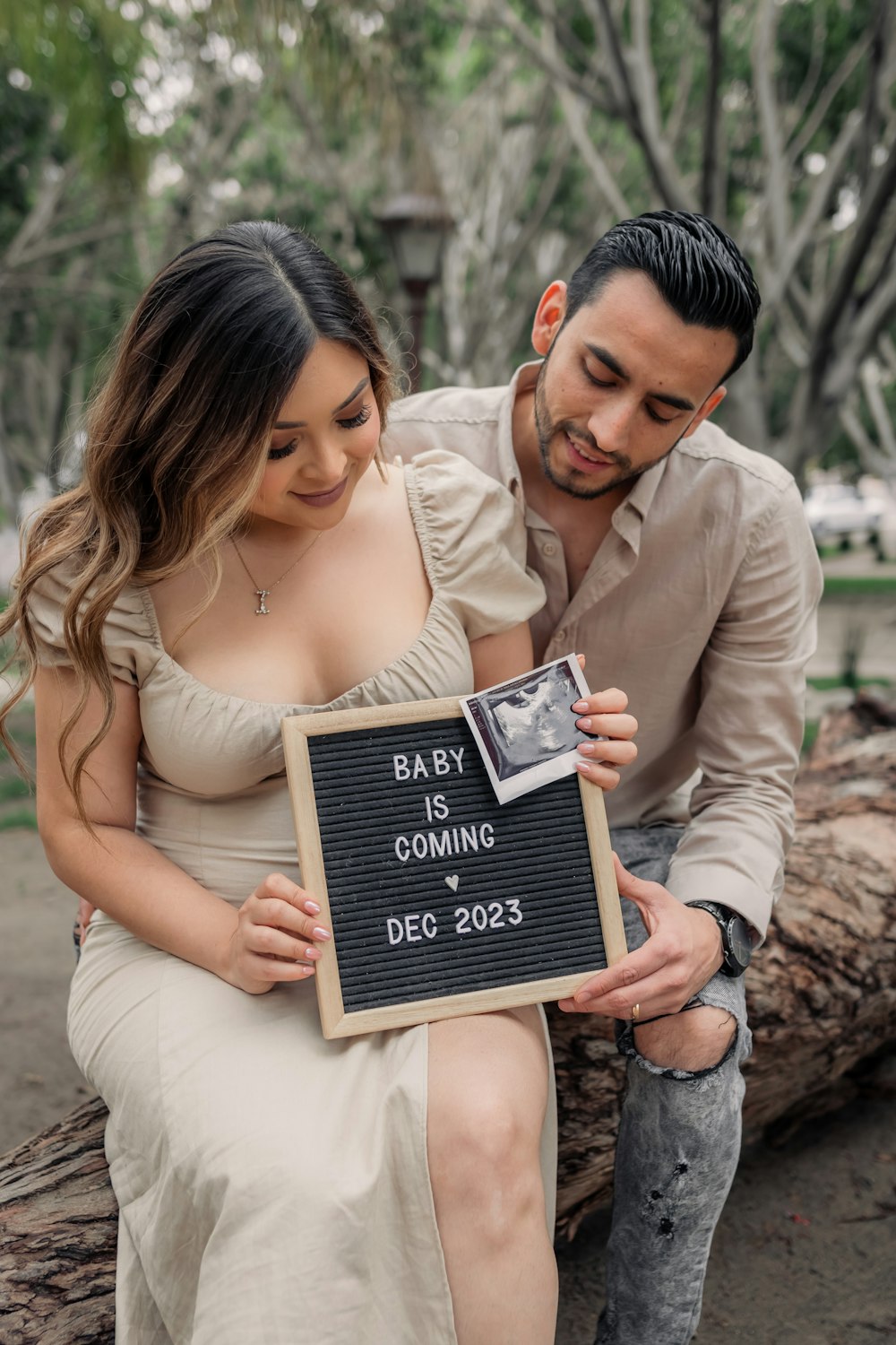 a man and woman holding a baby is coming sign